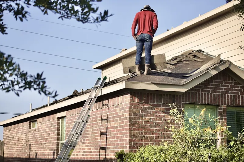 Professional roofer working on a residential roof in Patio Homes East